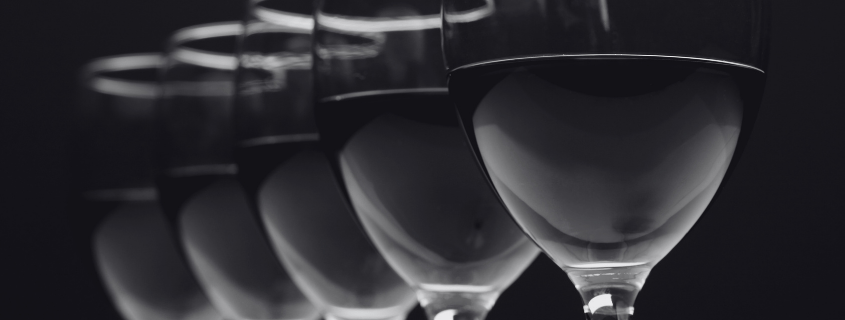 black and white shot of wine glasses lined up in a row
